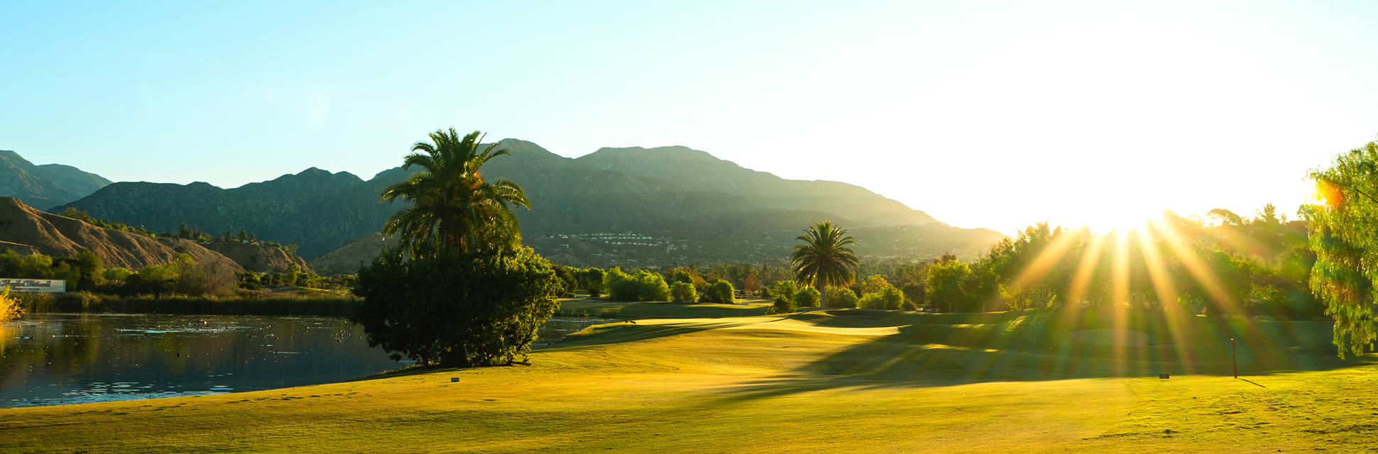 view of golf course green at golden hour
